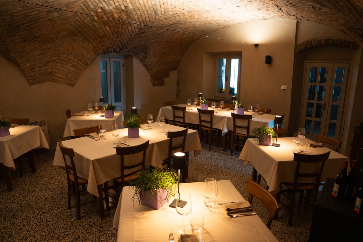 La sala con le volte in mattoni apparecchiata per la cena