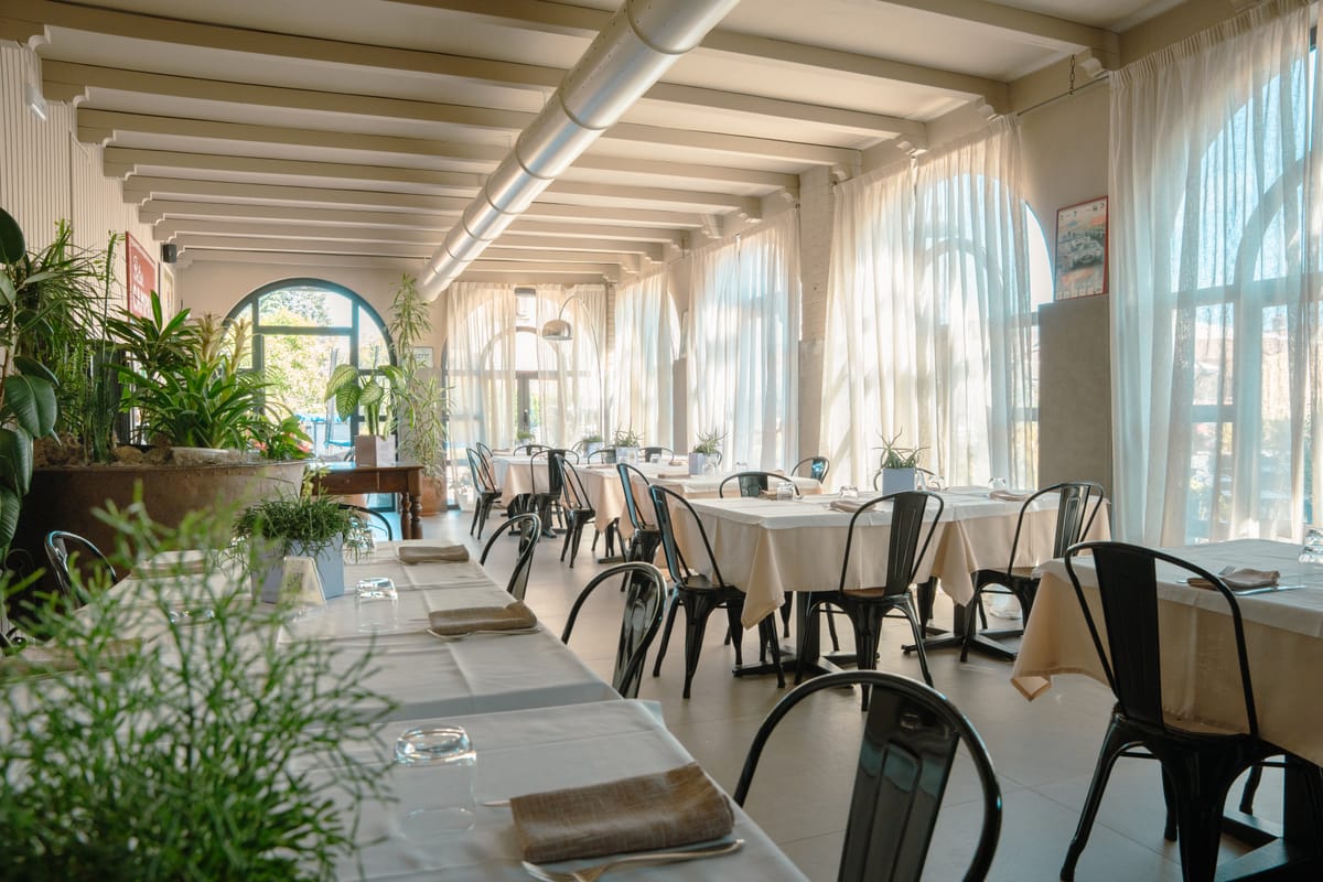 La veranda del ristorante con le finestre ad arco e le piante
